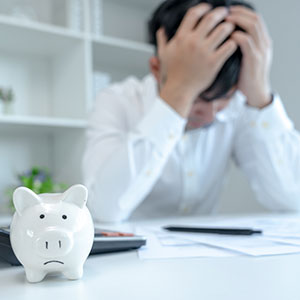 Short on Cash image of man with hands on his head and empty piggy bank